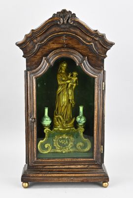 une petite horloge avec une statuette au centre