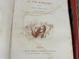 un livre ouvert sur une étagère, à côté d'autres livres