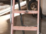 a ladder that is sitting in a garage next to a van