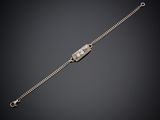 un bracelet en argent muni d'un fermoir, sur fond noir