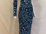 a woman ' s dress on a mannequin stand against a white backdrop