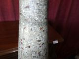 un vase posé sur une table, avec un rideau rouge en arrière-plan