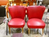 deux chaises rouges placées l'une à côté de l'autre dans une pièce