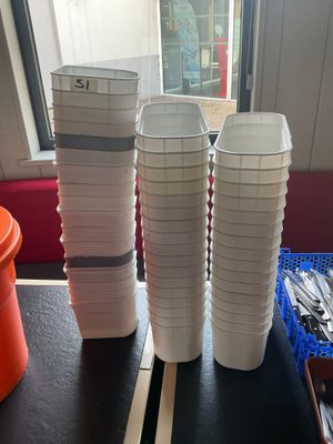 une table sur laquelle sont posées des tasses et des cuillères, devant une fenêtre