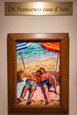 a painting of two people sitting on a beach