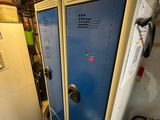 two blue lockers in a room with a fire extinguisher