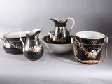 four pieces of black and white porcelain with floral designs on them