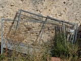 a pile of old metal frames leaning against a stone wall
