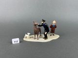 two figurines of a man with a dog and a man with a hat