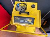 the yellow machine is sitting on the floor next to the red wall