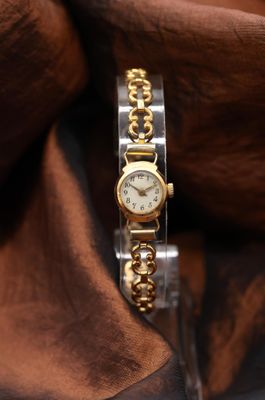 a watch that is sitting on top of a brown cloth