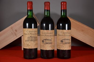 three bottles of red wine sitting next to each other on a table
