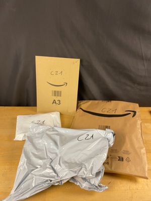 une boîte de produits amazon posés sur une table à côté d'un sac de papier