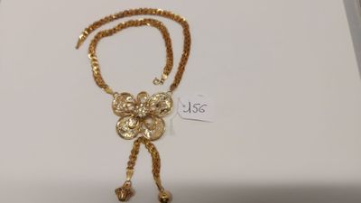 collier plaqué or présenté dans un écrin avec une étiquette de prix