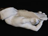 a statue of a hand holding a bird on a black surface