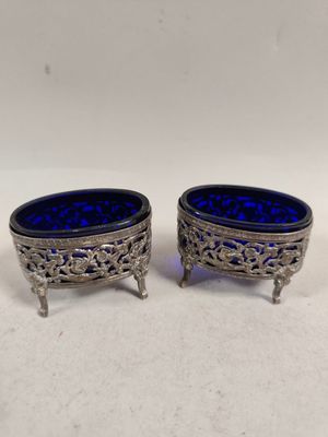 une paire de plats en verre argenté et bleu, posés sur des socles