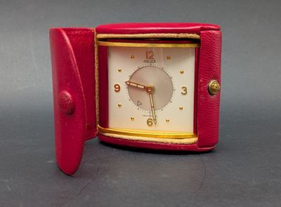 a small red clock that is sitting on a table