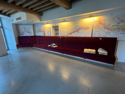 un canapé au milieu d'une pièce, avec une carte accrochée au mur