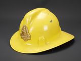 un casque de chantier jaune orné d'un emblème doré