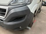 the front end of a white van parked in a parking lot