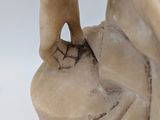 marble statue of a woman holding a bird on a pedestal