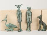 three bronze figurines of a man, a dog, and a bird