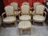six chaises et un pouf dans une pièce