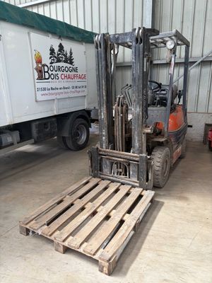 a forklift truck parked in a warehouse next to a truck
