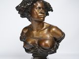 a bronze busturine of a woman with curly hair