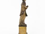 an antique bronze statue of a man holding a book