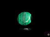 a close up of a green stone on a black surface