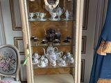 a display case with tea cups and teapots on it