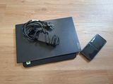 a black laptop and a cell phone on a wooden floor