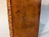 an old book with a note sticking out of it on a white surface