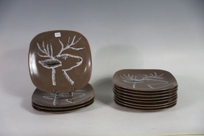quatre assiettes ornées d'un motif représentant un cerf, posées sur une table