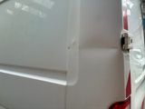a white van with a red stripe parked in a parking lot
