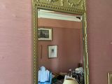 un miroir accroché au mur au-dessus d'une lampe dans une pièce