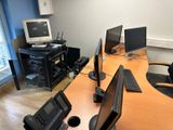 un bureau sur lequel sont posés deux écrans et un ordinateur portable