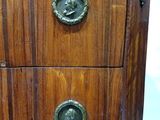 an image of a wooden chest of drawers with metal knobs