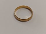 gros plan d'une bague en or sur une surface blanche