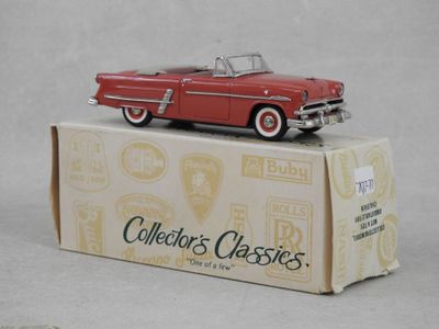 une petite voiture rouge posée sur une boîte
