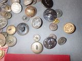 a lot of buttons on a table with a red book