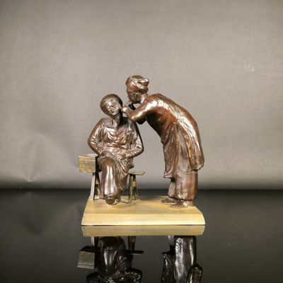 statue en bronze représentant une femme et un enfant assis sur un banc