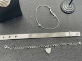 a silver bracelet and a silver bracelet on a table