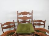 four chairs and a table with a green cushion on it