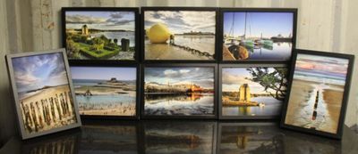quatre photos encadrées représentant différents paysages, posées sur une table