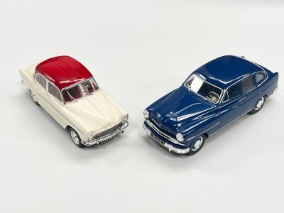 deux voitures jouets assises l'une à côté de l'autre sur une surface blanche