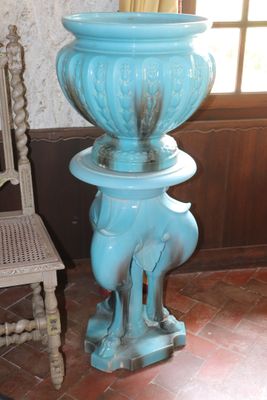 a large blue vase sitting on a pedestal in a room