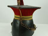 an old fashioned hat with a chain around it and a red hat on top of it