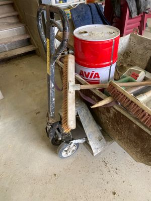 a red bucket sitting on top of a cart in a garage